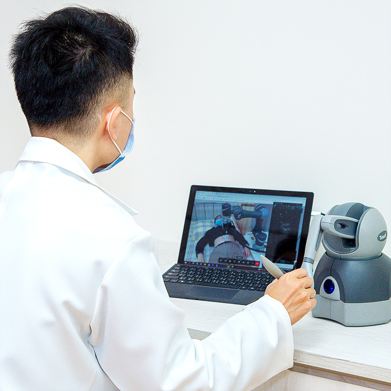 A physician uses a force feedback joystick to carry out remote robotic ultrasound scans.