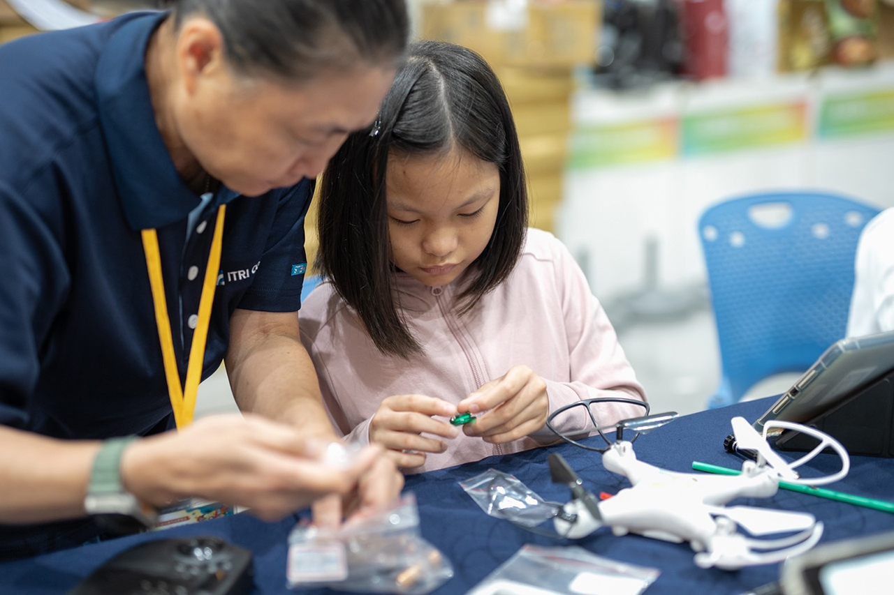 A camp participant (right) assembles the drone and learns about its visual recognition capabilities.