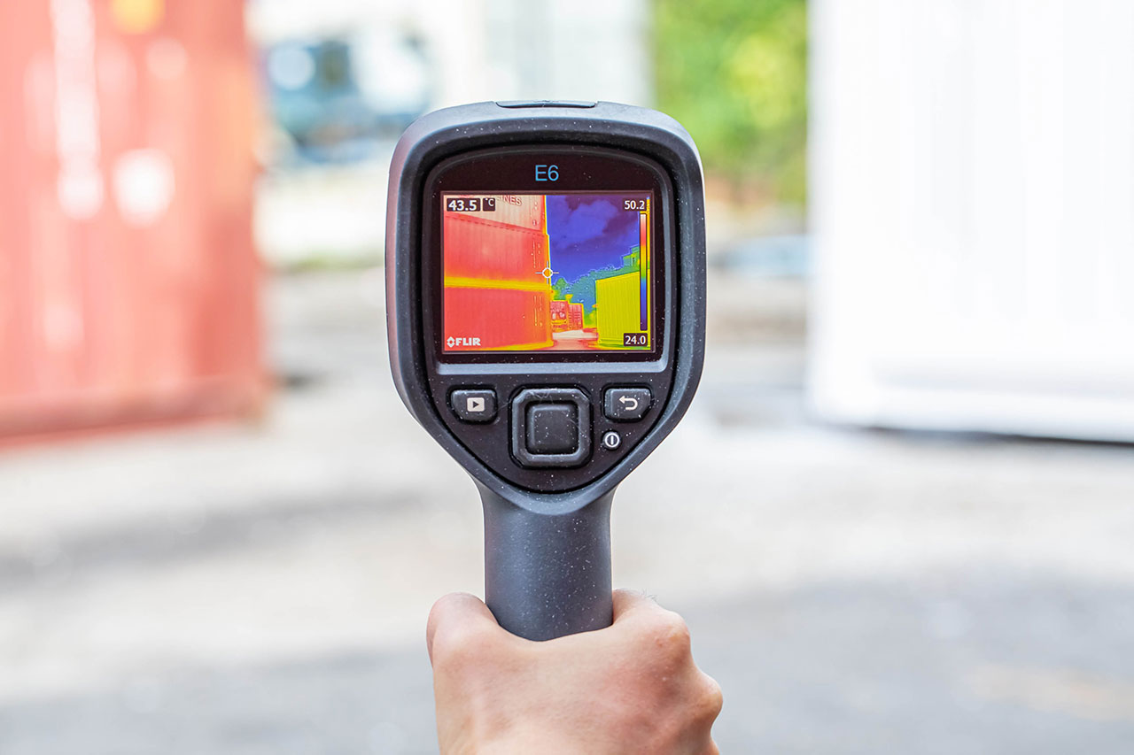 The coated container (right, in yellow) maintains a surface temperature roughly 12°C lower than the uncoated one (left, in red).