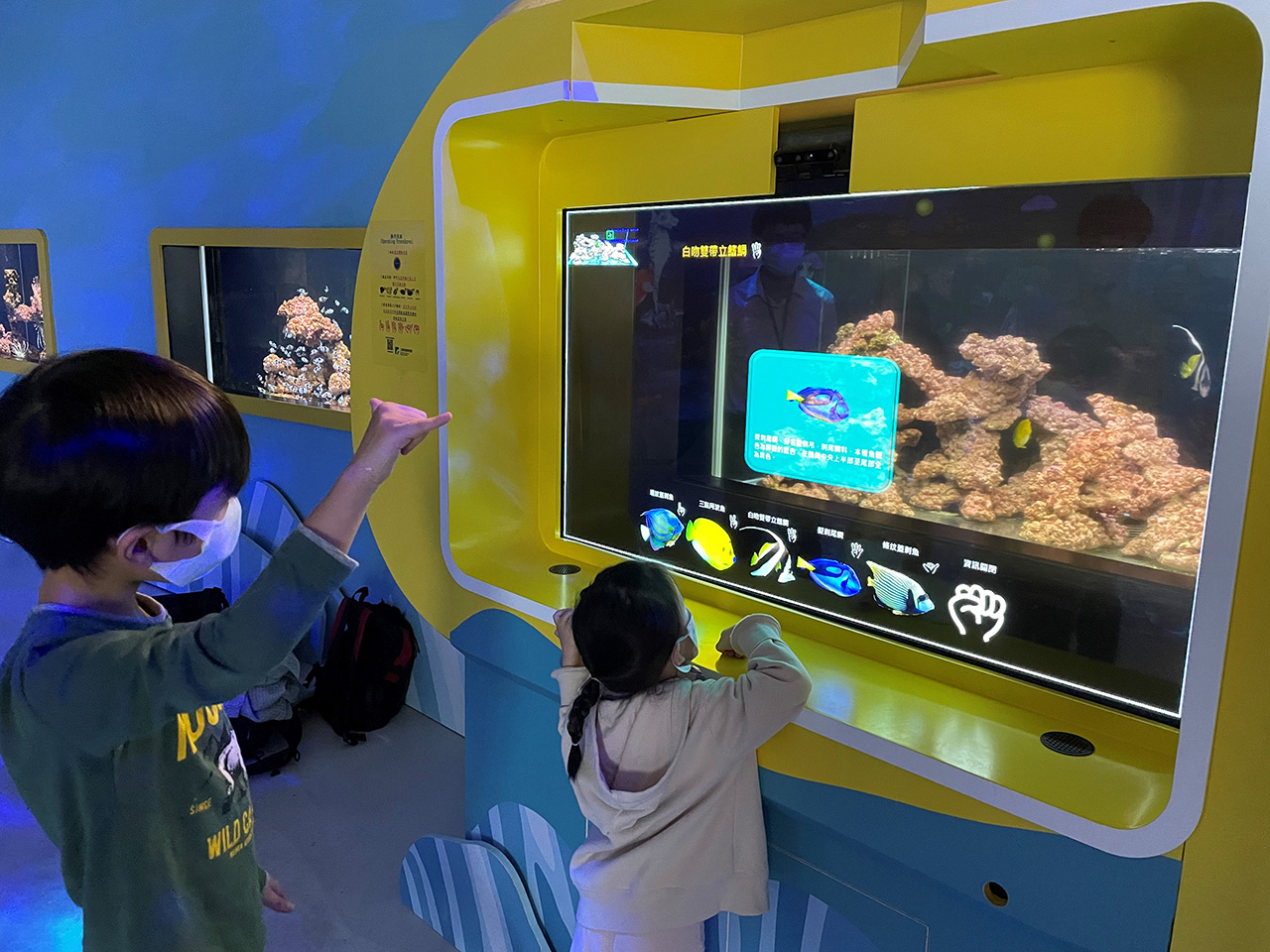 NeoVision AR displays real-time marine life information aligned with the user’s gaze and gestures in an aquarium setting.