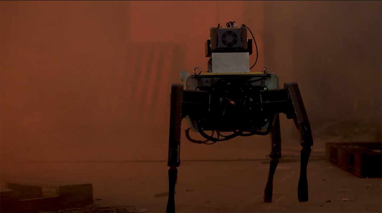 The larger quadruped robot conducts a reconnaissance mission in a simulated fire scene.