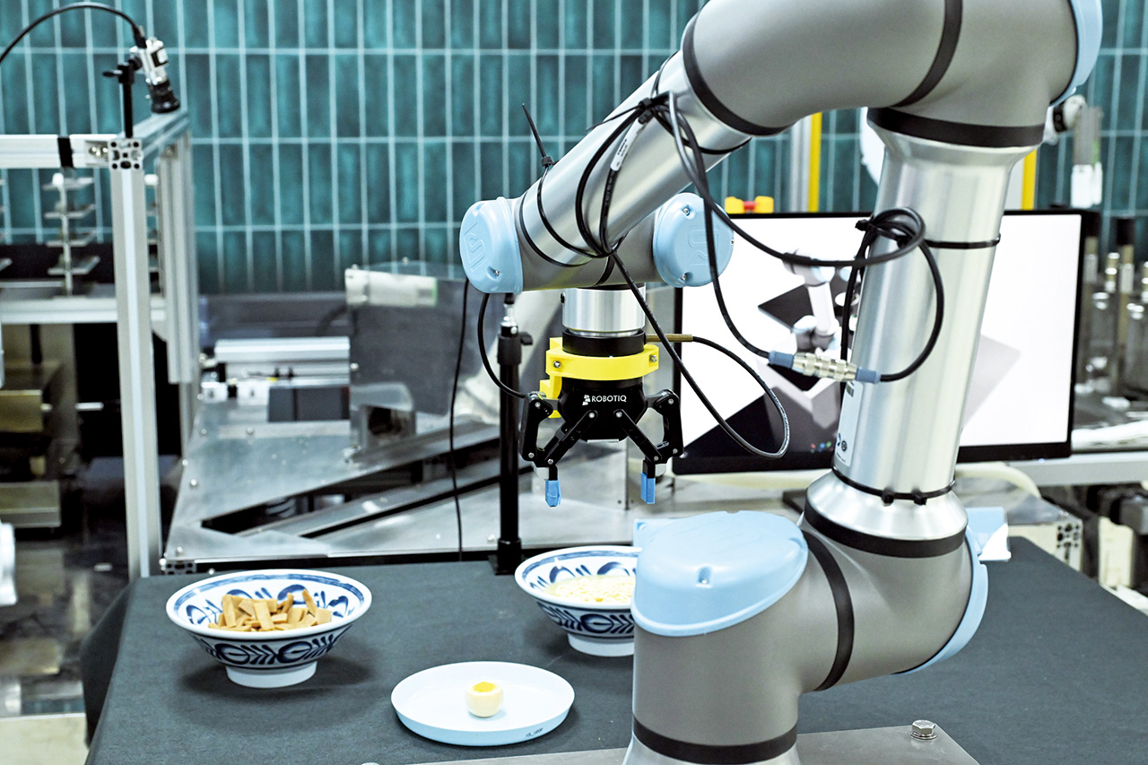 In another application of service robotics, a robot demonstrates automated ramen topping placement.